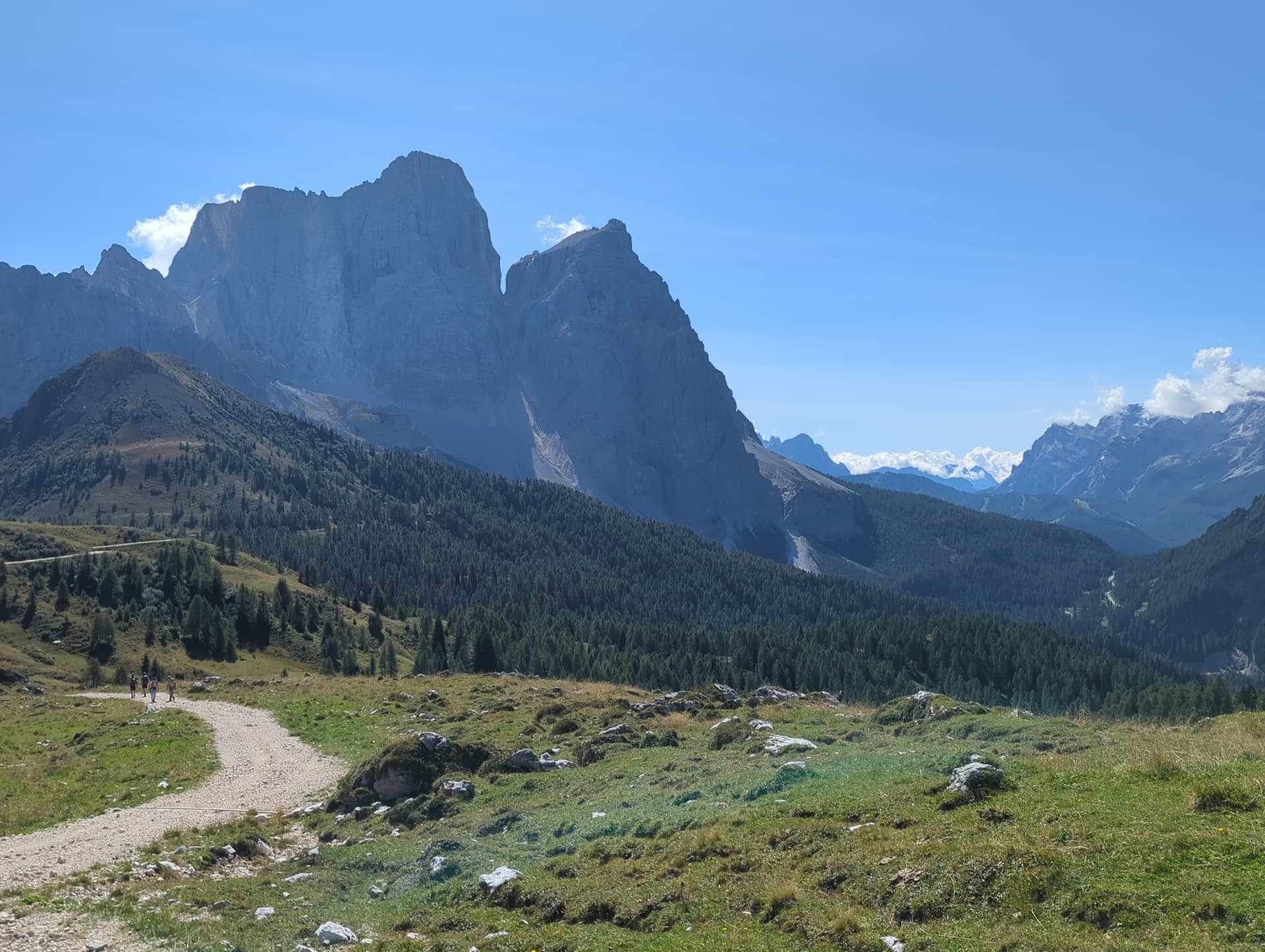 Hiking trail winding toward massive mountain peaks in alpine landscape