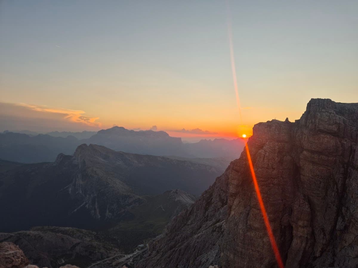Sunset over mountain peaks with dramatic lens flare